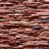 Ledge Stone wall cladding showcases a rugged texture, earthy red and brown tones, and a natural stacked pattern, ideal for an exterior facade or interior wall.