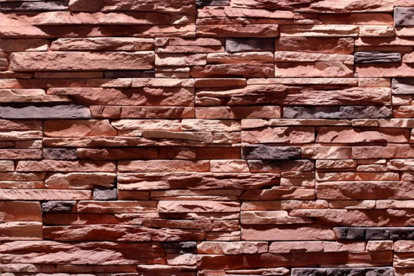 Ledge Stone 3 Ledge Stone wall cladding showcases a rugged texture, earthy red and brown tones, and a natural stacked pattern, ideal for an exterior facade or interior wall.