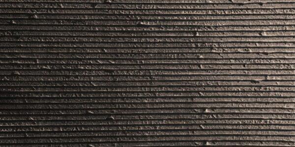 Flexible stone veneer in dark gray with horizontal ribbed texture, ideal for modern interior wall cladding or exterior facade with lightweight design.